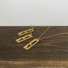 Håndskårne smykker i messing formet som Palæstinas kort.